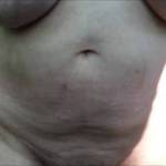 She has just spread baby oil over her big tits, and they are still dripping. She now lowers her underwear a little, then a little more, under the trees on a warm breezy afternoon