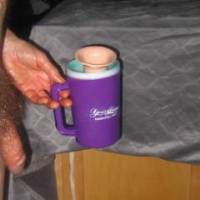 A side close view of my dick as I hold a plastic cup containing my toy on May 2ND 2025. A S70 camera was used.