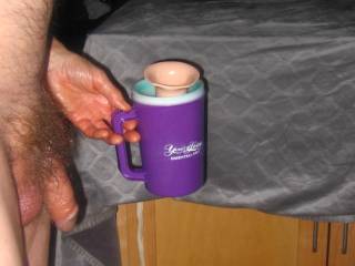 A side close view of my dick as I hold a plastic cup containing my toy on May 2ND 2025. A S70 camera was used.