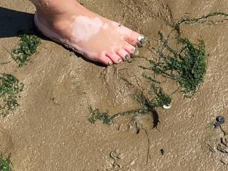 My naked feet in muddy sand