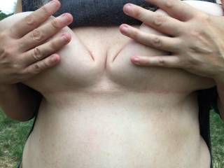 Playing with her big tits in a field