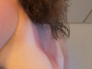 Side-view of wife’s big tits resting on her arm and hand.