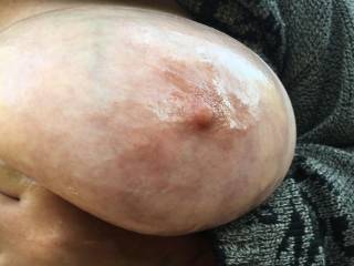 One tit finished, and now the gentleman works the baby oil in to the other one