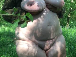Not much room in this woodland clearing, with a thorny plant on the left. However, she holds her oiled tits, plus getting her cunt out, on a sunny afternoon
