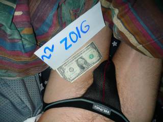 On my bed wearing my lingerie from Hung with a dollar bill nearby.