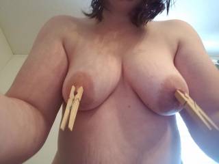 E using clothespins to squeeze her nipples hard