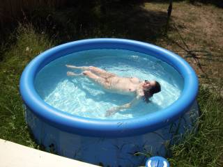 my wife layying back relaxing in pool on hot day