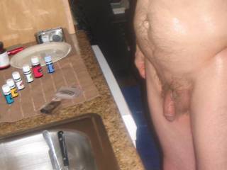 A frontal and side scene as I stand near my kitchen sink, with my aromatherapy oils that I consume during my toy play sessions  in late April of 2024. Camera used, G6.