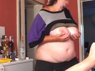 The photographer takes pictures of her cupping her big tits, while she turns and talks to his assistant