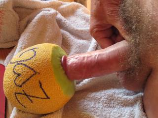 penetrating the small hole of a fresh and juicy melon