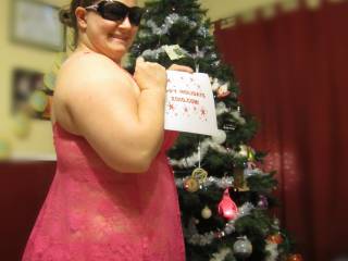 Showing off in my pink outfit in front of the Christmas tree.