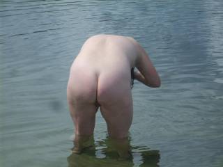 Barfb washing her haor in the lake, slightly bent over