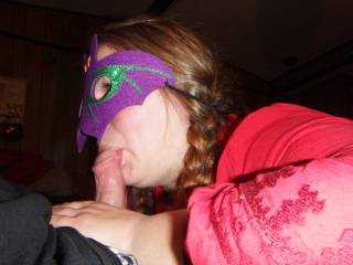 A side view of a masked blow job, playing with the tip