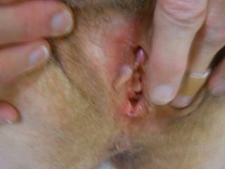 spreading and touching her lips. Getting a good look at her hard clit