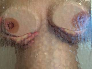 Pressing her pregnant tits against the shower glass