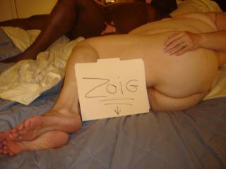 She is just relaxing with one of her fuck buddies after a two hour fuck session. I took the opportunity to prop the sign. Yes that is one of her BBC friends in the background.