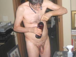 A partial body frontal as I stand opening a new bottle of massage lotion... I am creating a new mixture of essential/massage lotion... Late April 2025. One of the S70 camera`s was used.