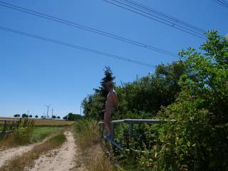 On this hot summer day, I had to present myself naked in public with a stiff cock. I was standing just a few meters from a country road and could have been discovered at any time.