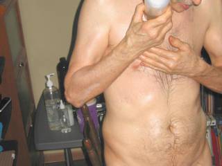 A partial body standing frontal as I pour essential oil/massage lotion upon my chest in late April of 2024. S70 camera was used.