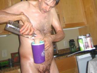 A partial body frontal as I stand in my kitchen and pouring some lube into my toy...late April of 2025... S70 camera was used.