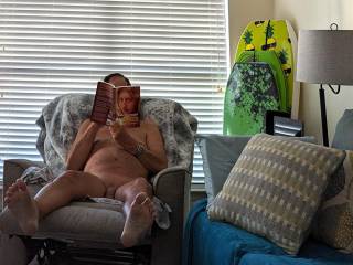 Relaxing by reading a book about the adventures of growing up in a nudist camp
