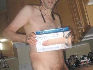 A partial body standing frontal view as I hold my new 8 inch hollow \'strap on\' toy that I will soak/wash, before use...My favorite toy`s are strap ons with out the strap...September 2025. 1 of 3 S70 camera`s was used.