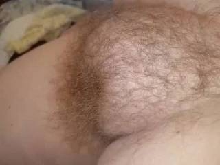 My wife laying on the bed with her big round hairy pussy mound exposed