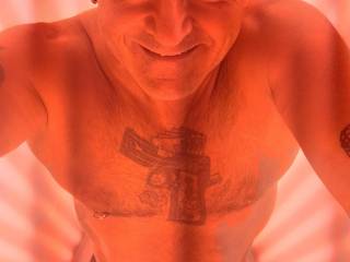 Naked inside red light therapy booth